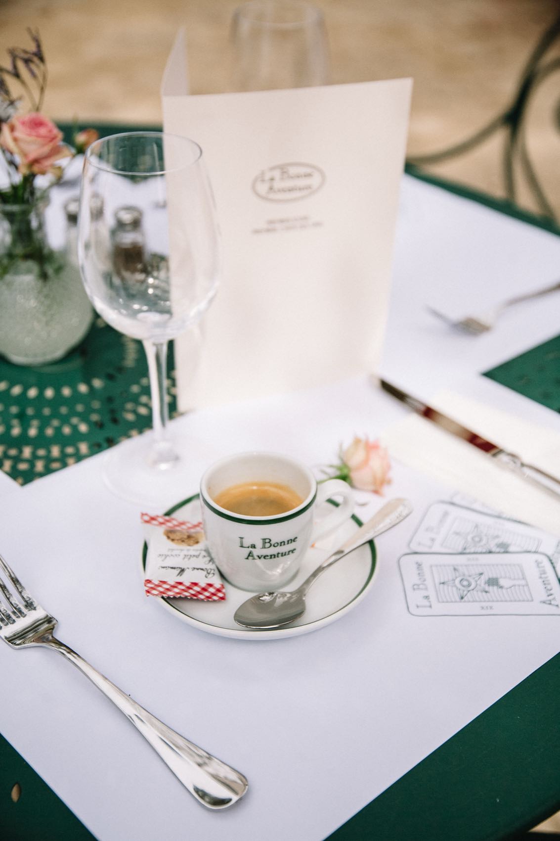 Un café servi dans la tasse siglée, posé sur le set de table où sont imprimées les cartes