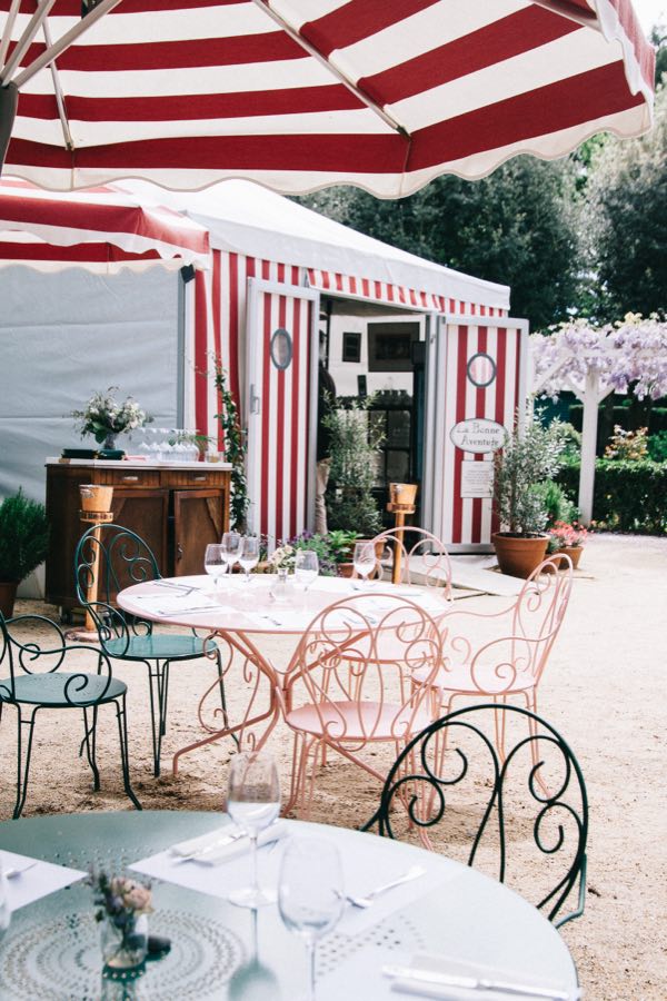 Le kiosque rayé rouge et blanc, vu depuis une table dressée sous un parasol