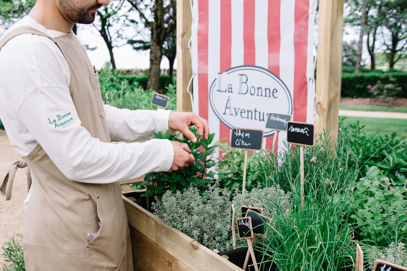 Le potager du salon de thé : bâche rayée siglée, bacs d’aromates et ardoises manuscrites