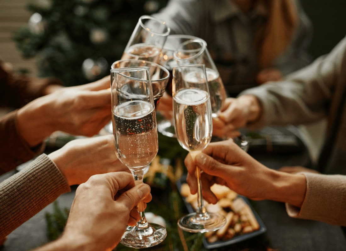 Des mains qui trinquent au-dessus d’une table dressée